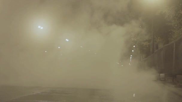 Man walking in night city street covered in white steam from sewerage accident
