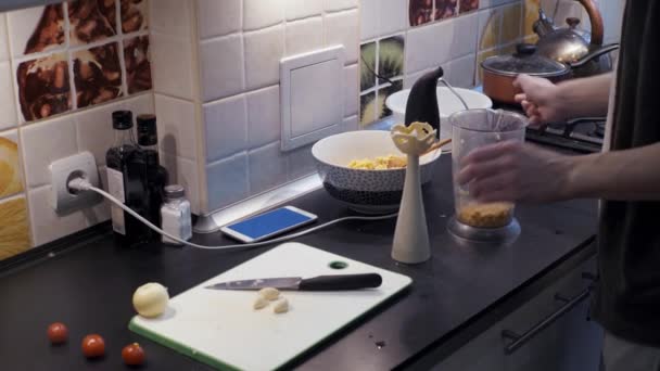 Hombre joven usando licuadora en la cocina y usando el teléfono inteligente de pantalla verde — Vídeos de Stock