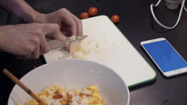 Ruce muže řezání cibule v domácí kuchyni. Mladý muž přípravě zeleninových pokrmů — Stock video