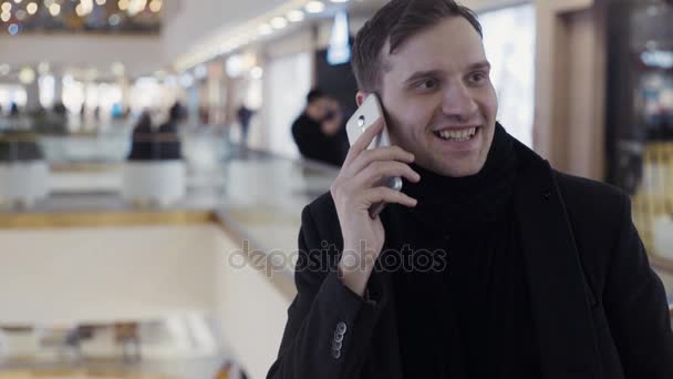 Kavkazská mladíci pomocí smartphone v shopping mall. Portrét