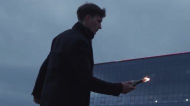 Genç adam elinde tutarak ve Molotof kokteyli ile şişe atma