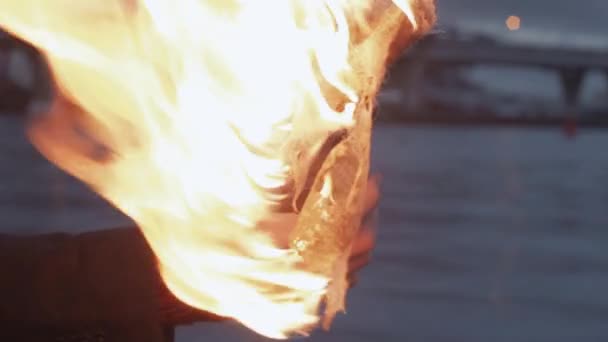 Młody protester Płonący koktajl Mołotowa w ręku stojąc na wybrzeżu — Wideo stockowe