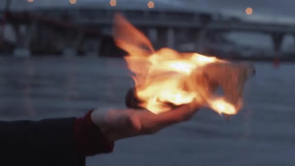 Jovem com um cocktail Molotov em chamas na mão em pé na costa — Vídeo de Stock