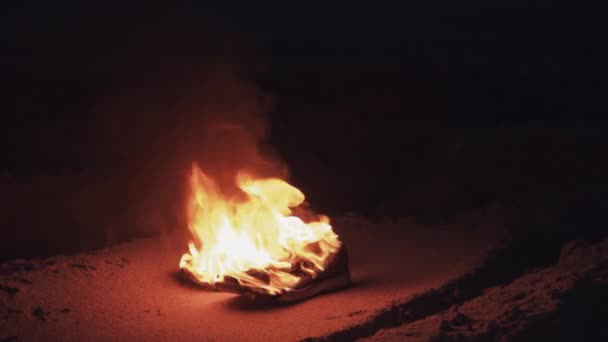 Палаючі черевики на піску на узбережжі сильний яскравий полум'я літньої темної ночі — стокове відео