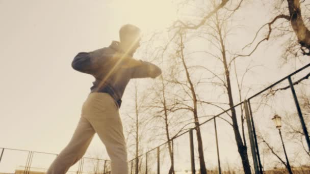 Young man doing sports exercises. Training at city athletic field. Sunny day. — Stock Video