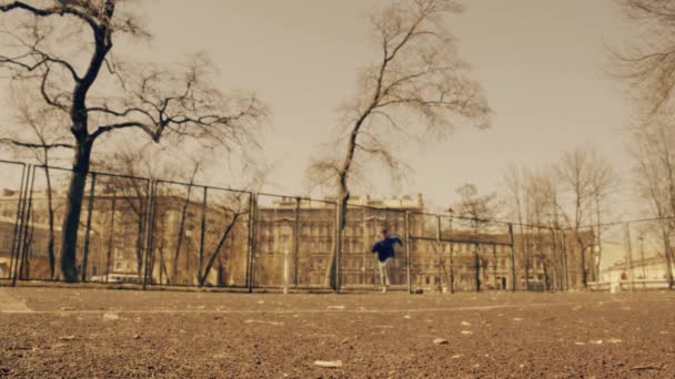 Молодой человек подбегает к камере, разворачивается и бежит назад. Обучение в городском парке . — стоковое видео