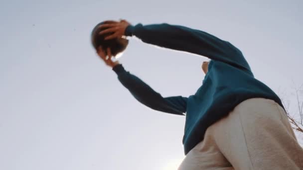 Joueur de football à la tête du ballon sous le ciel bleu au parc de la ville. Mouvement lent — Video