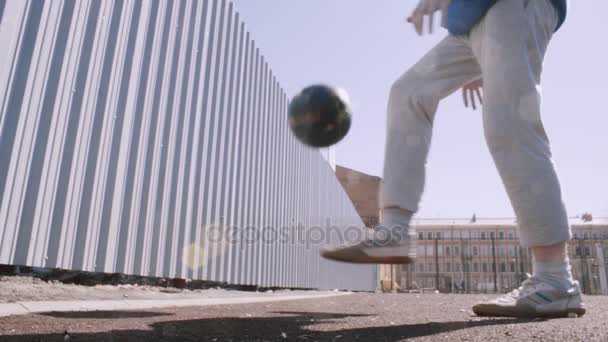 Labdarúgó játékos zsonglőr labda. Süt a nap. Foci képzés atlétikai pálya — Stock videók