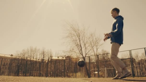 Piłkarz dryblingu i kopie piłkę. Piłka nożna w city park zwolnionym tempie — Wideo stockowe