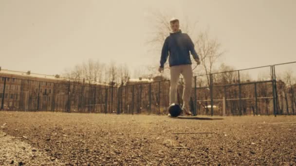 Футболист бежит к камере капает футбольный мяч вместе с ним . — стоковое видео