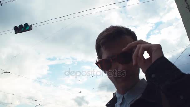 Людина злітає його сонцезахисні окуляри, приносить камерами об'єктив і ставить їх на — стокове відео