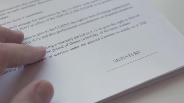 Mannenhand ondertekenen een contractformulier in zwarte inkt. Close-up shot. — Stockvideo