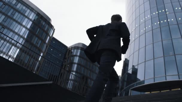 Ein junger Mann im Anzug kommt die Treppe hoch. Geschäftsmann zu Fuß zum Geschäftszentrum. — Stockvideo