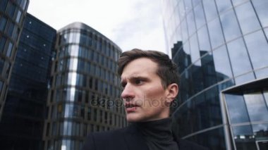 Takım elbiseli genç işadamı portresi. Arka bina İş Merkezi