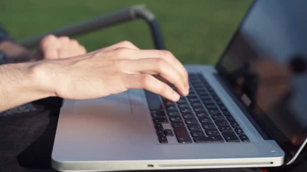 Manliga händer att skriva på laptop. Utomhus. Stadsparken — Stockvideo