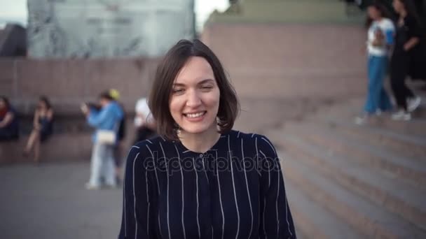 Посміхаючись молодій жінці в місті. Портрет дівчини з коротким волоссям . — стокове відео