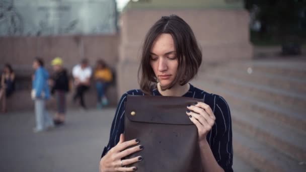 Mladá žena dát tašku přes rameno. Portrét dívky ve městě. — Stock video