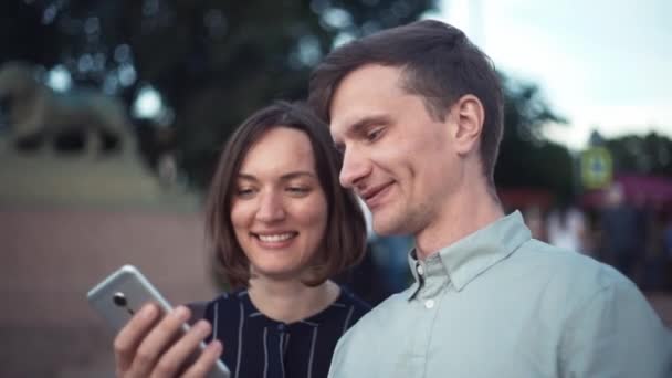Šťastný mladý tisícileté pár společně pomocí smartphone v parku — Stock video