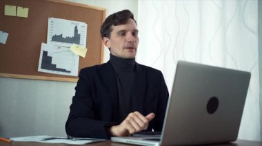 Genç işadamı dizüstü bilgisayar kullanan iş ortağı ile sohbet