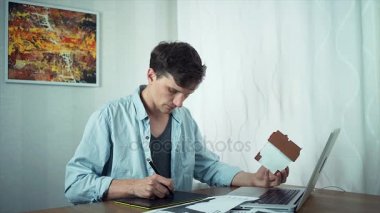 Freelancer tasarımcı dizüstü kullanarak Tablet konut projesi üzerinde çizim