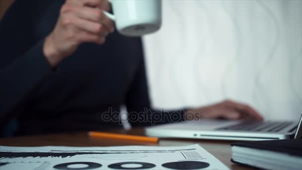 Erkek el alır bir fincan kahve yazdırılan bir rapordan — Stok video