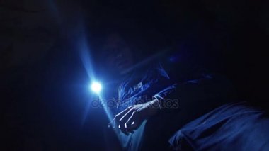 Adam dar mağaranın içine zemin döşeme el feneri ile mağara duvarları araştırıyor