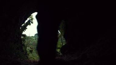 Genç uzun yürüyüşe çıkan kimse dört ayak üzerine karanlıkta çıkışları için mağara tarar ve ayağa kalkar
