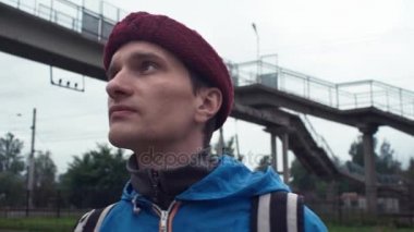 Sırt çantası konumu tren istasyonu olan genç hiker portresi