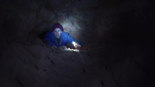 Turysta miesza w jaskini dziura świeci sposób z latarką w swoim smartfonie — Wideo stockowe