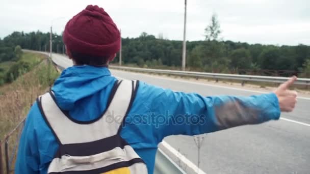 Baksida av vandrare vandring genom landsbygden lifta bilar — Stockvideo