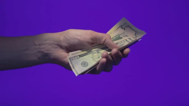 Mannenhand houdt en werpt vijftig dollar biljetten op chroma key scherm — Stockvideo