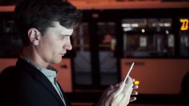 App bir kentsel sokakta taksi akşam içinde sipariş onun Smartphone kullanan adam