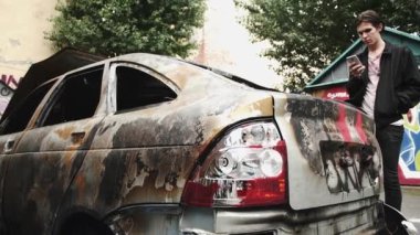 Smartphone ayakta çöktü yandı car yakınındaki kullanan genç adam. Kentsel yaşam tarzı