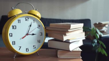 Erkek el kitabı raftan alır. Büyük sarı Saat işliyor