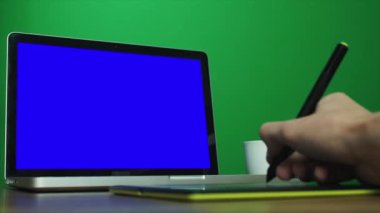 Erkek bir dijital çizim tableti ve bir dizüstü bilgisayar kullanarak eller. Chroma anahtar arka plan vasıl