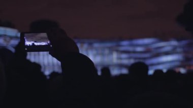 İnsanları vuruyor 3d eşleme ışık gösterisi bir cep telefonu.