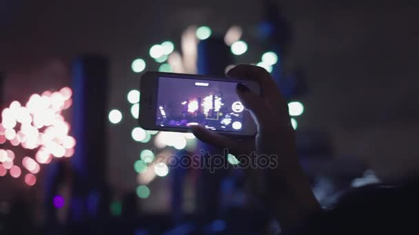 Ruka s smartphone. Žena pořídí ohňostroje na mobilní telefon. — Stock video