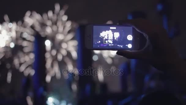 Mão de menina com smartphone. Mulher dispara fogos de artifício em um telefone celular . — Vídeo de Stock