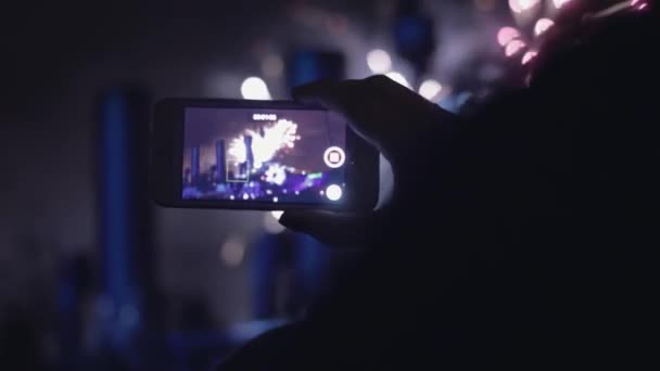 Jovem atira fogos de artifício em um telefone celular — Vídeo de Stock