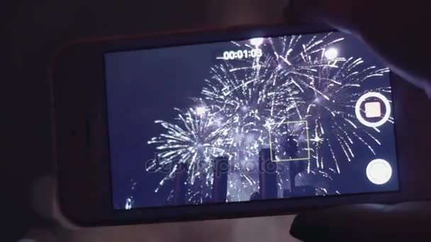 Ręka przy wideo do programu fireworks na smartfonie. Z bliska — Wideo stockowe