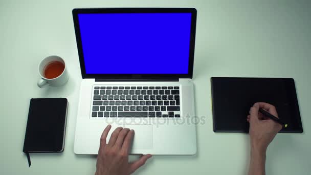 Top vue mains masculines en utilisant onglet graphique et ordinateur portable avec écran vert au bureau blanc — Video