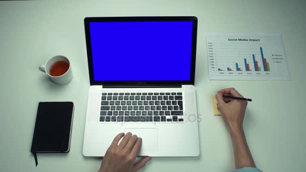 Вид зверху чоловічі руки, використовуючи липкі нотатки і ноутбук з зеленим екраном — стокове відео