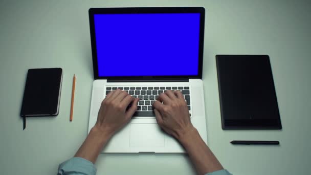 Vista superior de las manos masculinas utilizando ordenador portátil con pantalla verde en el escritorio blanco . — Vídeo de stock