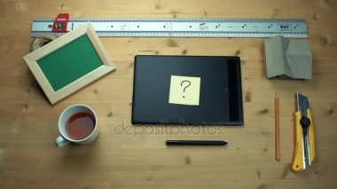 Masa başında grafik tablet kullanarak soru işareti ile yapışkan not koyarak adam