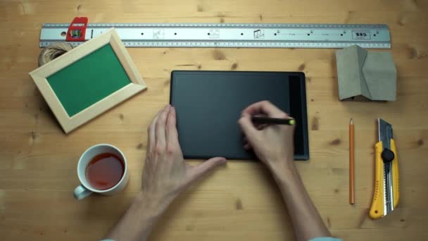 Felülnézet férfi leosztást használ digitális grafikus digitalizáló tábla, fából készült íróasztal. — Stock videók