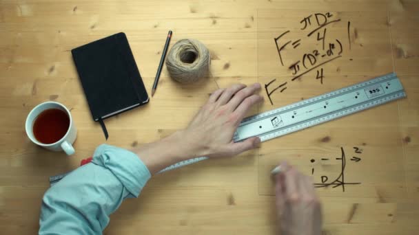 Αρσενική χέρι γράφοντας μαθηματικοί τύποι μαθηματικά σύμβολα στο πλαστικό ποτήρι με μαύρο μαρκαδόρο — Αρχείο Βίντεο