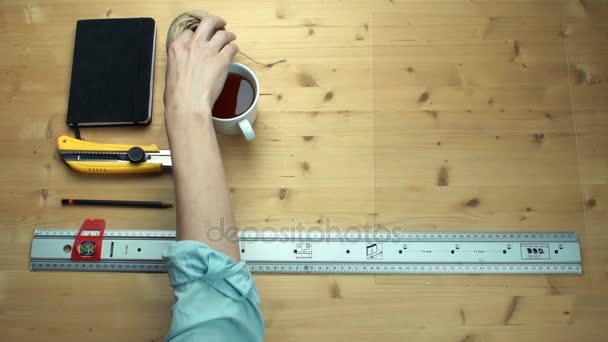 Vue de dessus main mâle plaçant des fournitures de travail au bureau en bois — Video