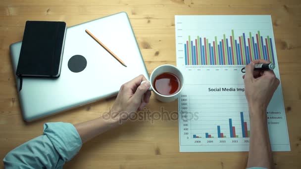 Top view male hands working with printed graphs making notes with marker — Stock Video