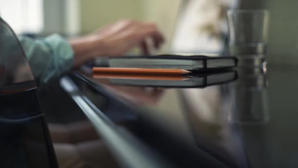 Close up of pencil on desk. Defocused objects glass, male hands on laptop — Stock Video