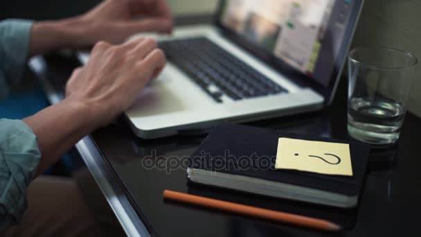 Freelance utilisant un ordinateur portable à la maison. Note collante avec signe de question sur le bureau — Video